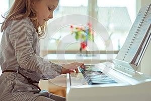 Cute little girl has training with piano