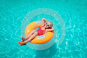 Cute little girl have fun at the pool, child relax in floatie