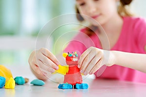 Cute little girl having fun with colorful modeling clay at a daycare