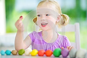 Cute little girl having fun with modeling clay at a daycare. Creative kid molding at home.