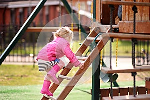 Cute little girl having fun on outdoor playground