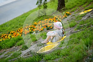 Cute little girl having fun outdoors on sunny summer evening. Child exploring nature