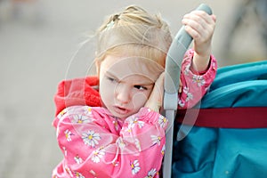 Cute little girl having fun outdoors on sunny summer evening. Child taking a walk in the city