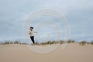 cute little girl having fun playing in the sand dunes