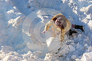 Cute little girl having fun in snowfall. Children play outdoors winter season in snow.