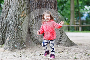 Cute little girl having fun with soap bubbles