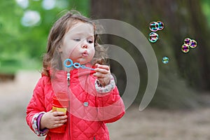 Cute little girl having fun with soap bubbles