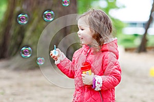 Cute little girl having fun with soap bubbles