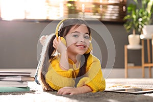 Cute little girl with headphones listening to audiobook