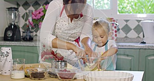 Cute little girl helping her mother bake