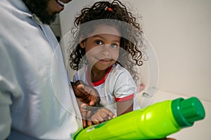 Cute little girl and her cheerful dad at the launderette