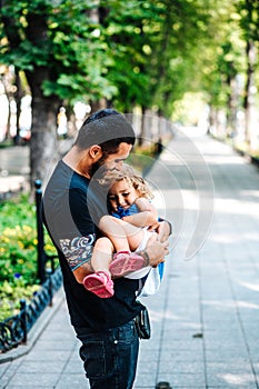 Cute little girl in her father`s arm