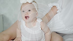 Cute little girl and her mom are spending time together and laughing. Happy baby in a good mood. Daughter and mother