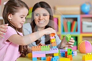 Cute little girl and her mother playing