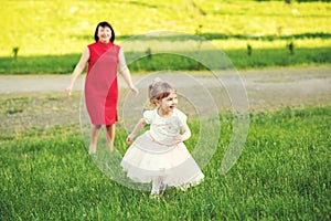 Cute little girl and her young grandmother playing outdoor.