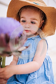 Cute little girl holding big artichoke flower in hands