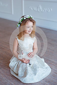 Cute little girl holding a bunny. Spring and easter portrait of beautiful child with rabbit.