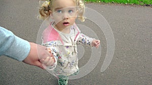 Cute little girl holding father hand and walk together