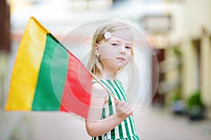 Cute little girl holding tricolor Lithuanian flag