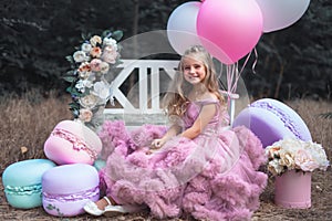 Cute little girl holds French Macaron. Confectionery concept