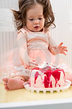 Cute little girl touching sweet cake