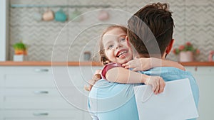 Cute little girl hugging daddy in living room