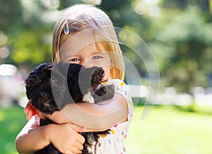 Cute little girl hugging dog puppy
