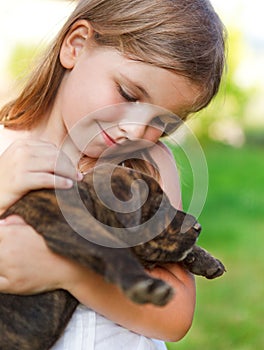 Cute little girl hugging her dog puppy.