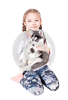 Cute little girl hugging a husky puppy, isolated on a white.