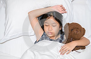 Cute little girl hugging teddy bear sleeping lay in  bed