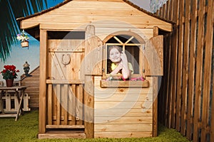 Cute little girl inside wooden house