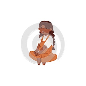 Cute little girl in jumpsuit sits on the floor. Happy kid with pigtails, braids. Funny small child rests, relaxes. Baby