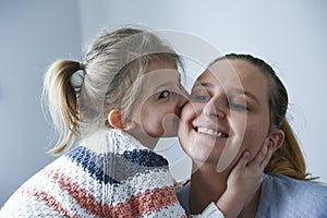 Cute little girl kissing her mother