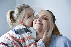 Cute little girl kissing her mother