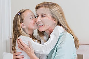 Cute little girl kissing her mother