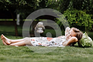 Cute little girl is laughing and lying on the grass with the cabbage . Mother`s Day, love family, parenthood, childhood concept