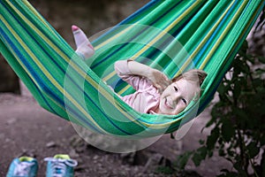 Cute little girl laughing while lying in hammock