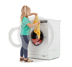 Cute little girl with laundry near washing machine