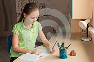 Cute little girl left-handed writing her homework