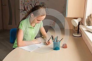 Cute little girl left-handed writing her homework