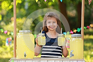Cute little girl at lemonade stand. Summer refreshing natural drink