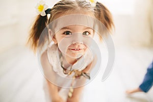 Cute little girl looking at the camera in closeup and smiling. Funny photo