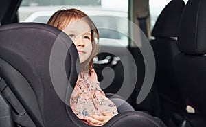 Cute little girl looks through window car. Conception of traveling and vaccation photo