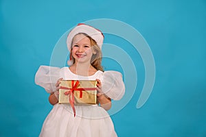 Cute little girl in a lush blom dress for a holiday. fun child in Santa hat hold gift Happy merry Christmas. beautiful