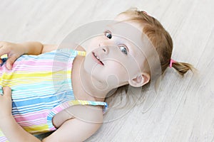 Cute little girl lying on the floor in the children`s room