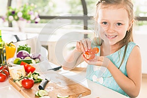 Cute little girl making salad. Child cooking. Healthy food