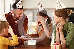 Cute little girl making wish while celebrating Birthday with family at home