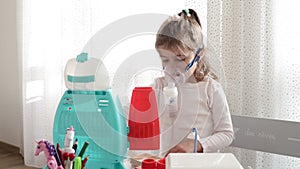Cute little girl in the mask of an inhaler. Playing with toys. Procedure of inhalation at home.