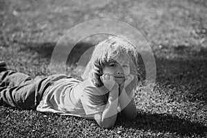 Cute little girl on the meadow in spring day. Happy childhood. Boy lying on grass. Cute kid child enjoying summer on