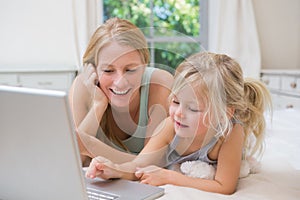 Carino poco un madre sul un letto computer portatile 